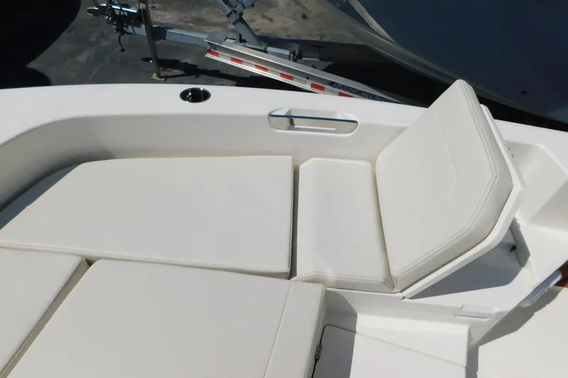Slide: The Image of 2026 Pathfinder 2400 TRS boat seating area with white cushions and cup holder. - 7