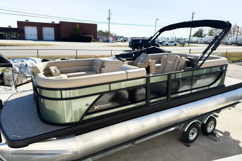 The Image of 2026 Godfrey Sweetwater Xperience 22' Split Bench Tritoon, sleek design, parked on trailer. - 2