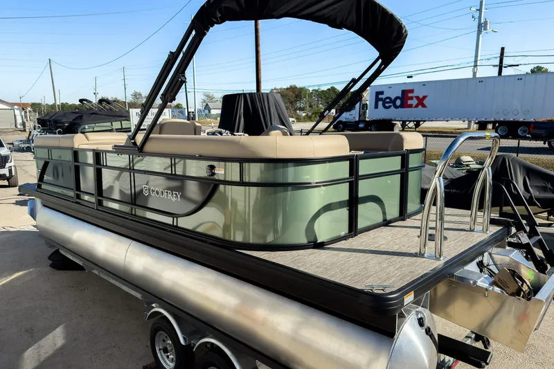 Slide: The Image of 2026 Godfrey Sweetwater Xperience 22' Split Bench Tritoon, parked on a trailer, side view. - 6