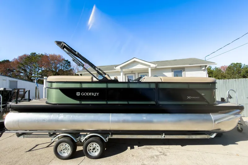 Slide: The Image of 2026 Godfrey Sweetwater Xperience 22' Split Bench Tritoon on trailer, parked outdoors. - 7