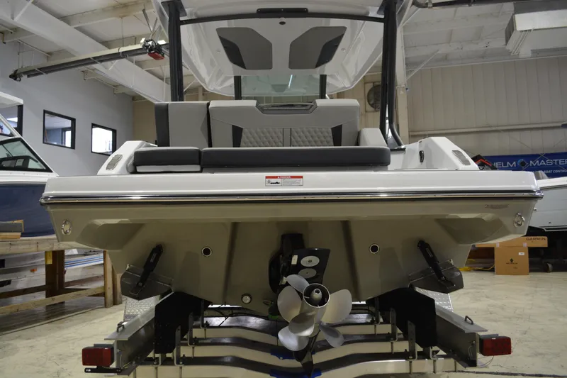 Slide: The Image of 2026 Monterey Elite 27 SD boat in showroom, rear view with propeller and seating. - 12