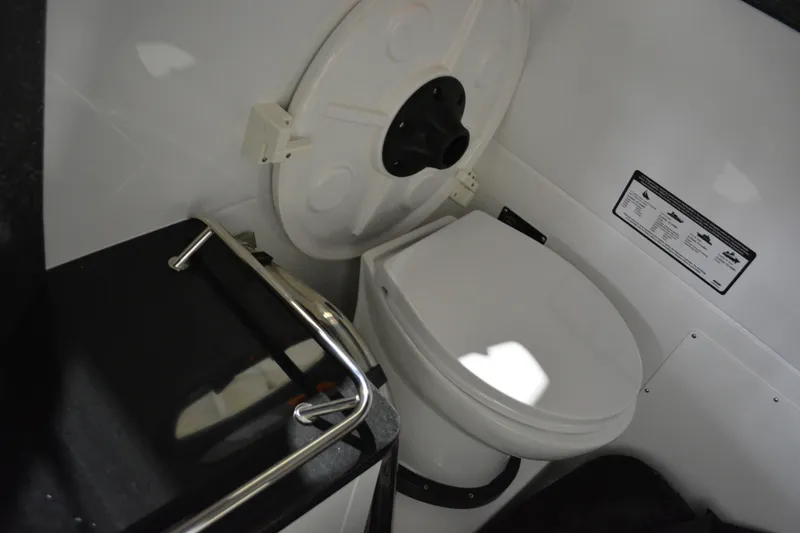 Slide: The Image of Interior of 2026 Monterey Elite 27 SD boat, featuring a compact marine toilet. - 28