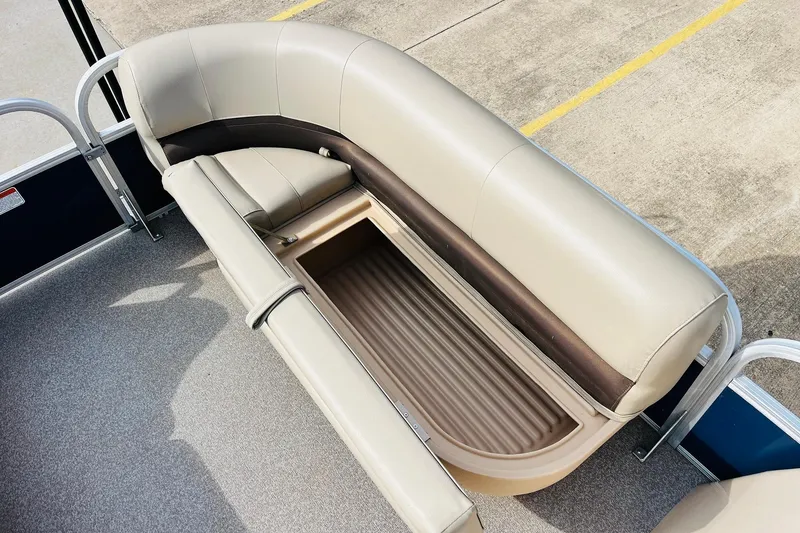 Slide: The Image of 2019 Sun Tracker Party Barge 18 DLX with open storage compartment under beige seating. - 18