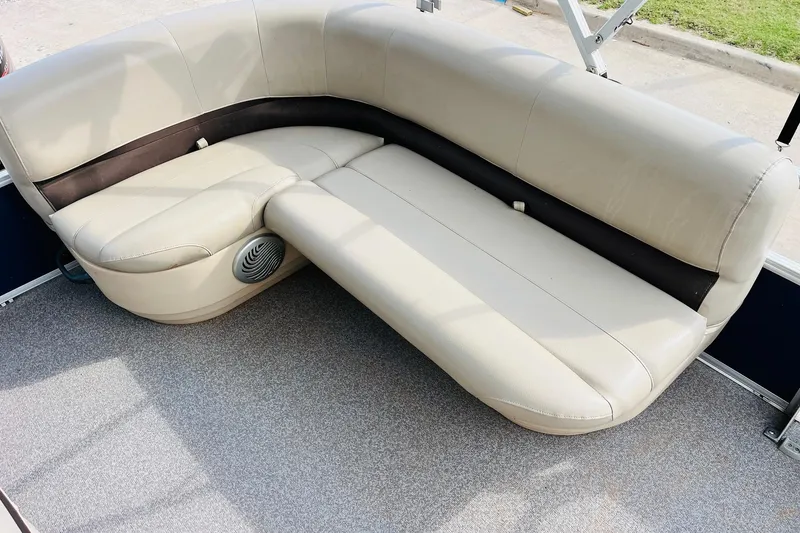 Slide: The Image of 2019 Sun Tracker Party Barge 18 DLX beige seating with speaker, on gray carpeted deck. - 22