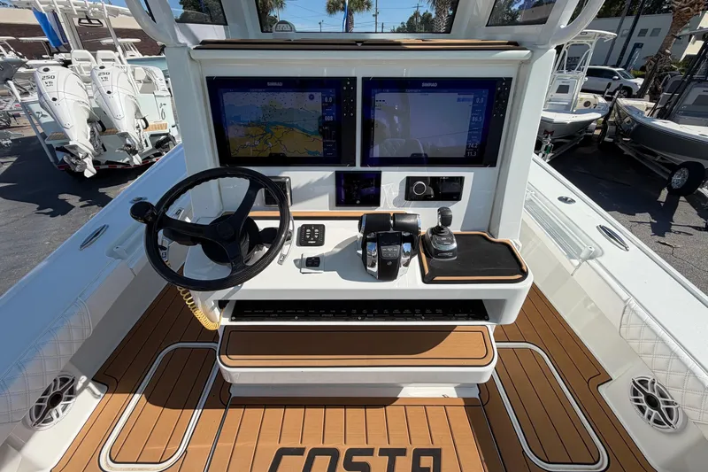 Slide: The Image of 2023 Costa Custom Boats 264 HC helm with dual screens and modern controls. - 16