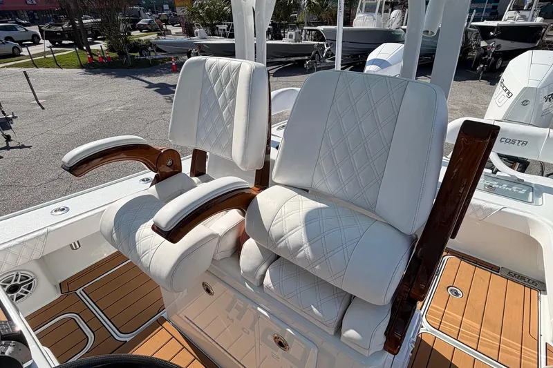 Slide: The Image of 2023 Costa Custom Boats 264 HC, luxurious white seating with wooden armrests, outdoor setting. - 19