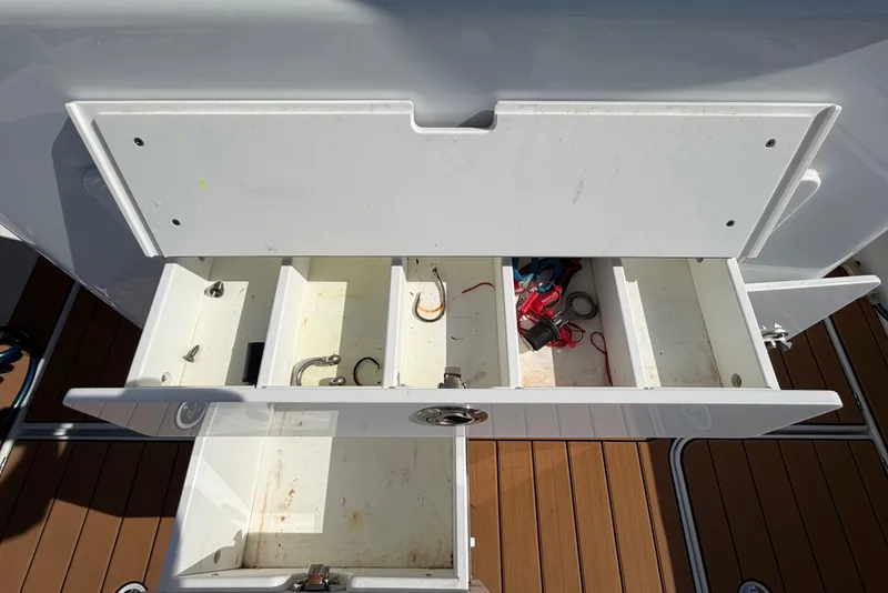 Slide: The Image of Open storage compartments on 2023 Costa Custom Boats 264 HC, showcasing organized fishing gear. - 30