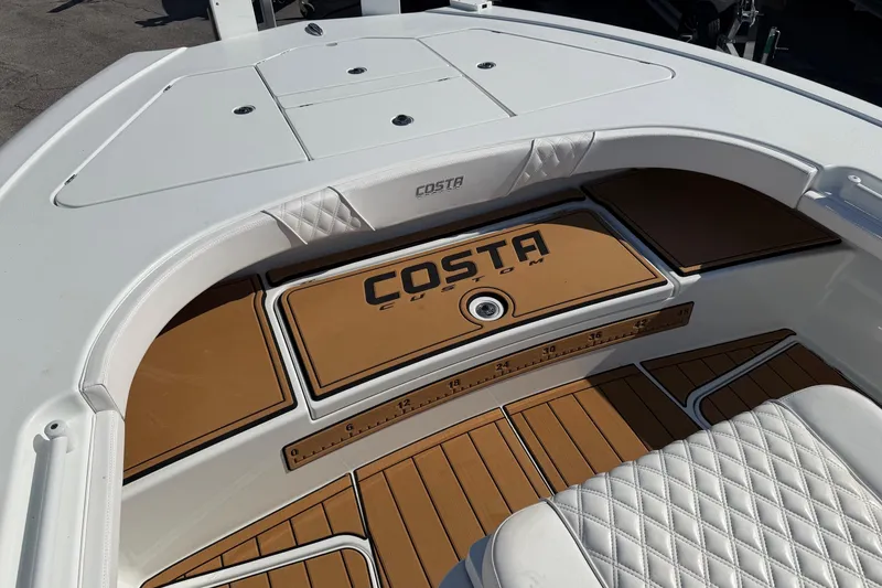 Slide: The Image of 2023 Costa Custom Boats 264 HC interior with tan and white seating and deck. - 34