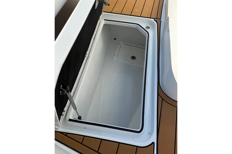 Slide: The Image of Open storage compartment on 2023 Costa Custom Boats 264 HC, featuring teak flooring. - 44