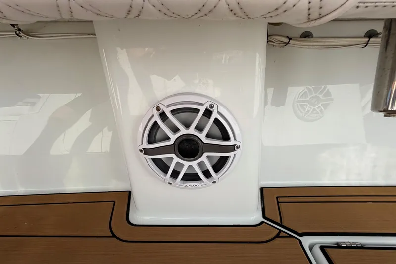 Slide: The Image of Speaker on 2023 Costa Custom Boats 264 HC, featuring teak deck and white upholstery. - 53