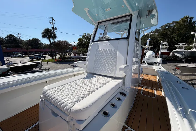 Slide: The Image of 2023 Costa Custom Boats 264 HC with luxurious seating and sleek design in a sunny outdoor setting. - 9