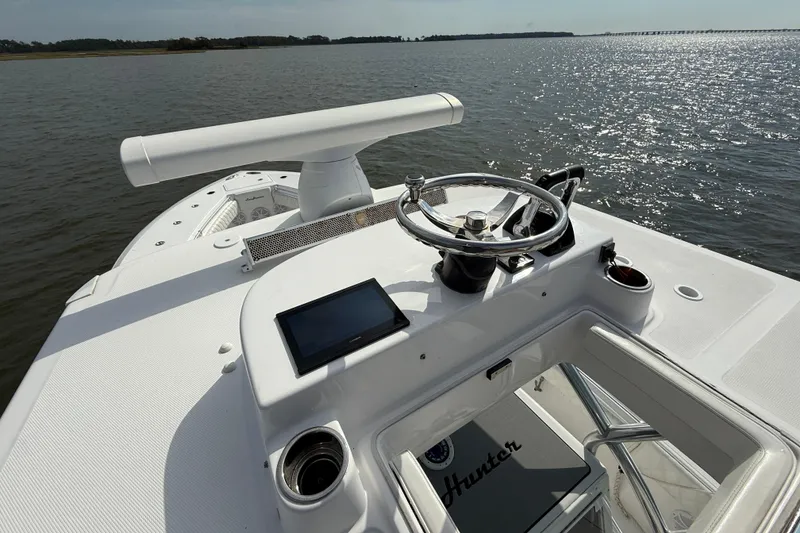 Slide: The Image of 2018 SeaHunter 35 Tournament boat helm with steering wheel and navigation screen on calm water. - 103
