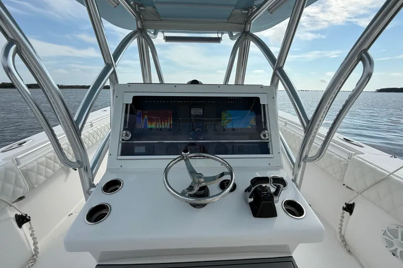 Slide: The Image of 2018 SeaHunter 35 Tournament boat console with steering wheel and navigation screens. - 52