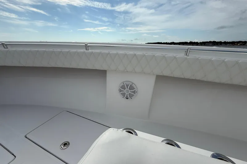 Slide: The Image of 2018 SeaHunter 35 Tournament boat interior with cushioned seating and speaker, under a blue sky. - 93