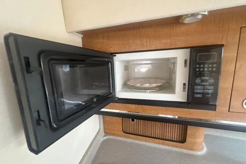 Slide: The Image of Microwave inside 2006 Sea Ray 290 Amberjack boat, open door, wooden cabinetry. - 32