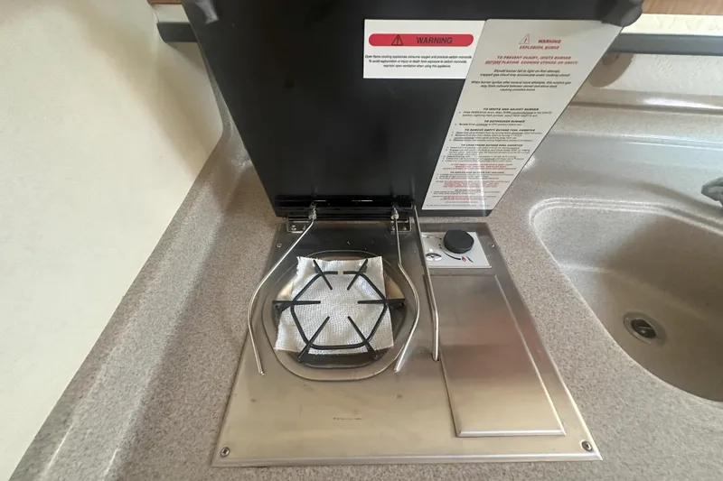 Slide: The Image of Stovetop in 2006 Sea Ray 290 Amberjack boat kitchen, featuring safety instructions. - 33