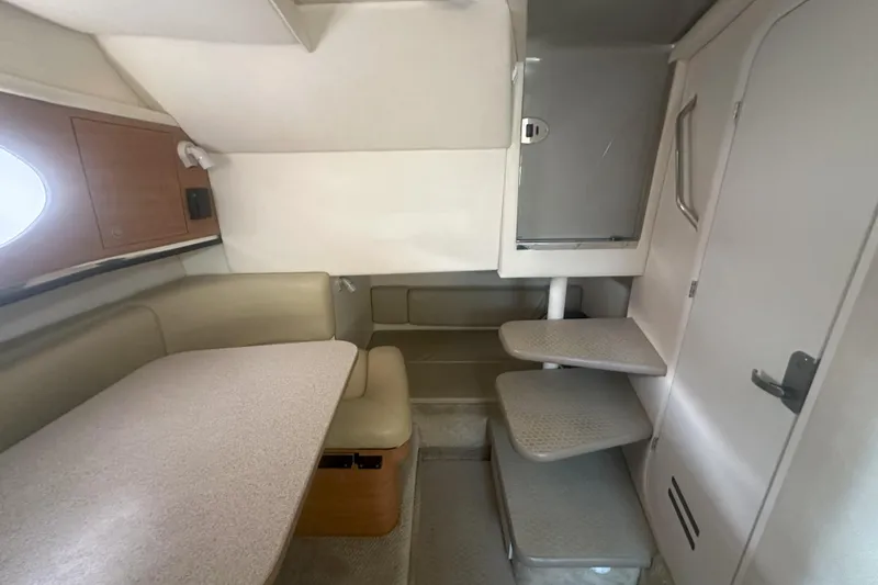 Slide: The Image of 2006 Sea Ray 290 Amberjack cabin interior with seating, table, and stairs. - 28
