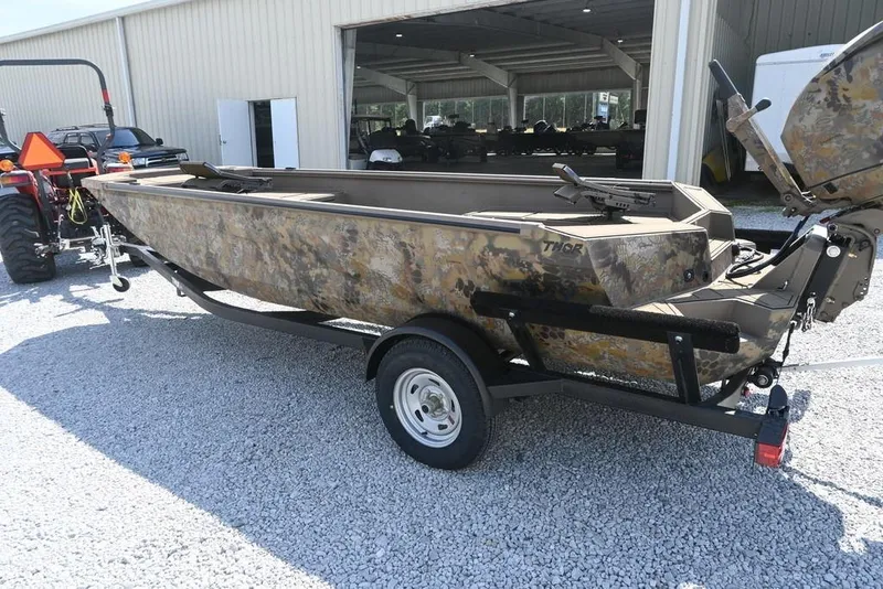 Slide: The Image of 2026 Thor 1754 camouflage boat on trailer outside a warehouse. - 3