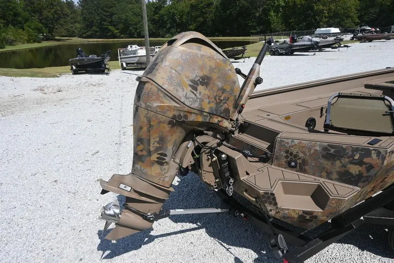 Slide: The Image of Camouflage-patterned Thor 1754 boat engine, 2026 model, parked on gravel near a pond. - 5