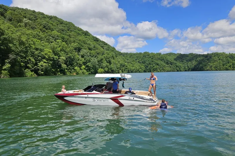 Slide: The Image of Varatti Z2373 boat on a lake with people enjoying water activities, surrounded by lush greenery. - 11