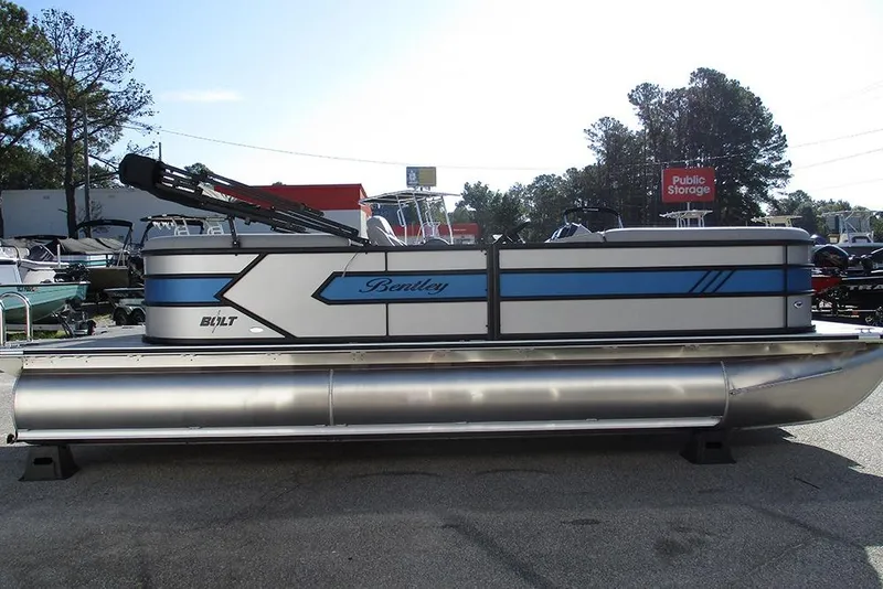 Slide: The Image of 2026 Bentley Pontoons 223 Bolt pontoon boat in a parking lot, side view. - 6
