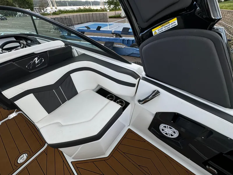 Slide: The Image of 2022 Monterey 258 Super Sport boat interior with white and black seating, cup holders, and speaker. - 14