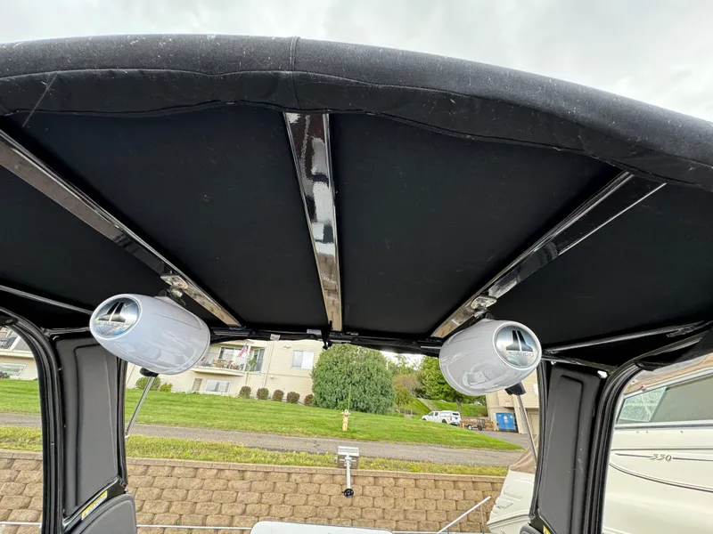 Slide: The Image of 2022 Monterey 258 Super Sport boat canopy with mounted speakers, outdoor setting. - 46