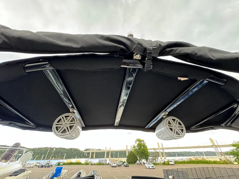 Slide: The Image of 2022 Monterey 258 Super Sport boat canopy with speakers, overlooking a scenic waterfront. - 47