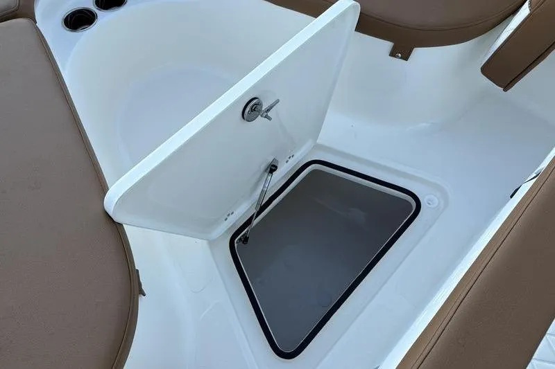 Slide: The Image of Open storage compartment on 2026 Pioneer Islander 222 boat with brown seating. - 26