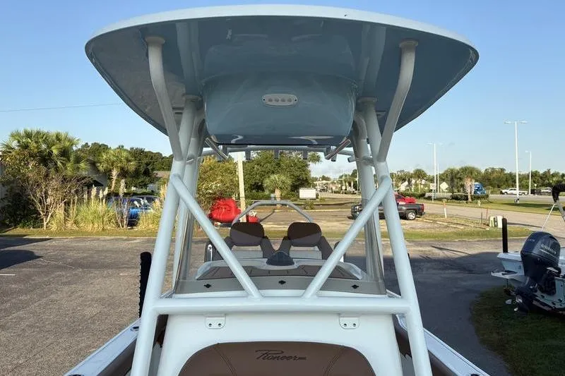 Slide: The Image of 2026 Pioneer Islander 222 boat with T-top, parked outdoors on a sunny day. - 28