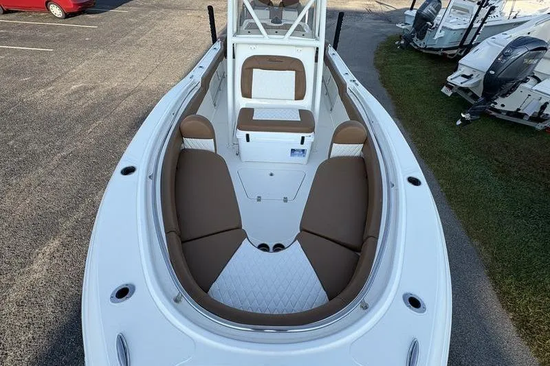 Slide: The Image of 2026 Pioneer Islander 222 boat interior with brown and white seating, docked outdoors. - 32