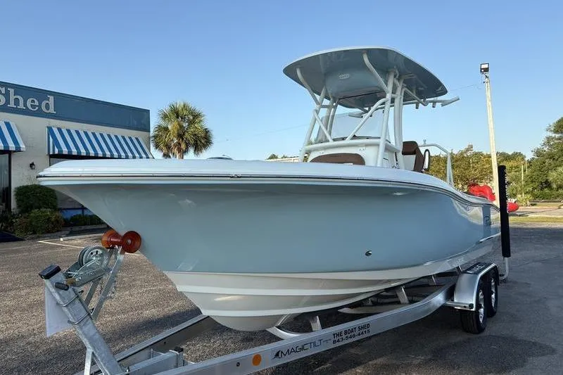 Slide: The Image of 2026 Pioneer Islander 222 boat on trailer, parked outdoors near a building. - 8