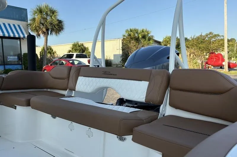 Slide: The Image of 2026 Pioneer Islander 222 boat interior with brown and white seating, outdoor setting. - 9