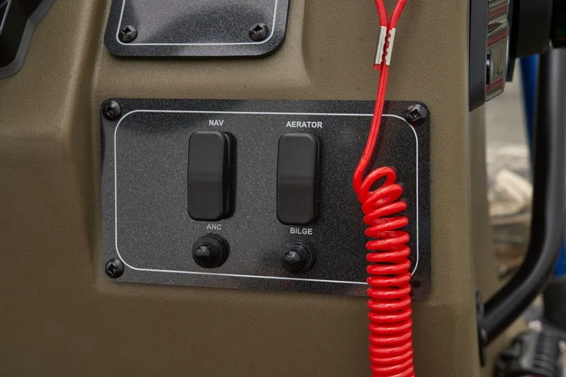 Slide: The Image of Control panel of 2026 Tracker Grizzly 1860 CC boat with switches and red coiled cord. - 33
