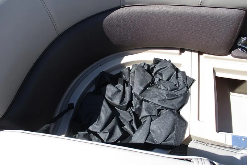 Slide: The Image of 2026 Bentley Pontoons 223 Legacy Swingback interior storage compartment with black fabric cover. - 15