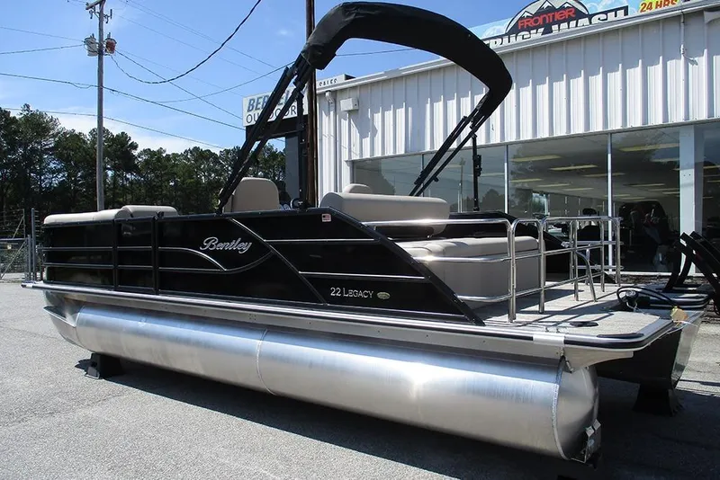 Slide: The Image of 2026 Bentley Pontoons 223 Legacy Swingback, black pontoon boat, parked outside dealership. - 2