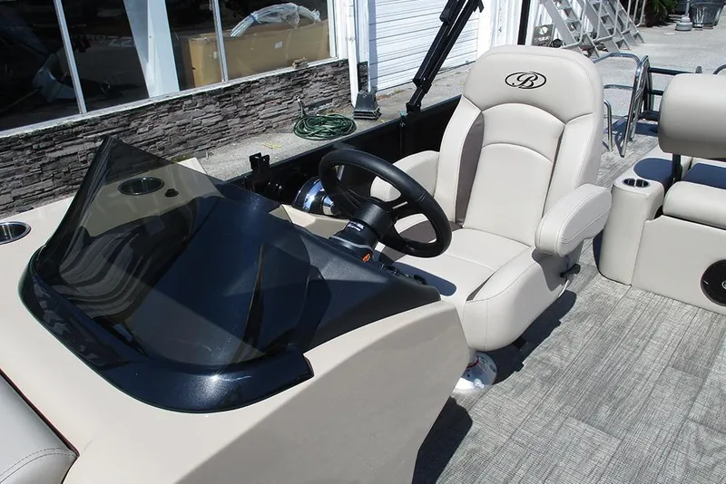 Slide: The Image of 2026 Bentley Pontoons 223 Legacy Swingback interior with steering wheel and beige seating. - 27