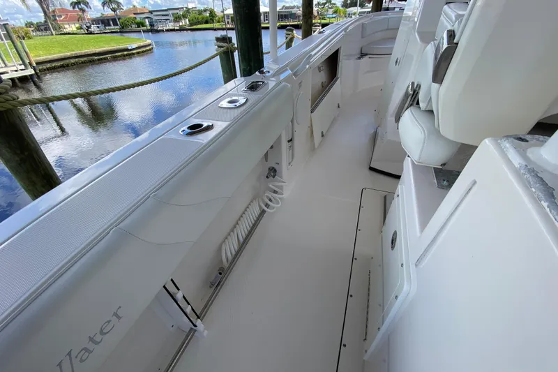 Slide: The Image of 2015 Edgewater 320CC boat interior with white seating and waterfront view. - 13