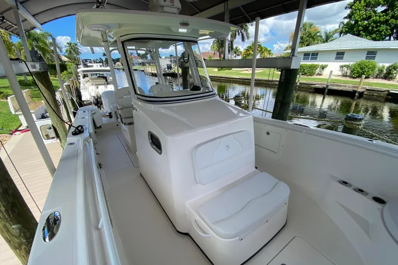 Slide: The Image of 2015 Edgewater 320CC boat docked, featuring spacious seating and sleek design. - 15