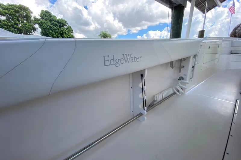 Slide: The Image of 2015 Edgewater 320CC boat interior with sleek white design and storage features. - 22