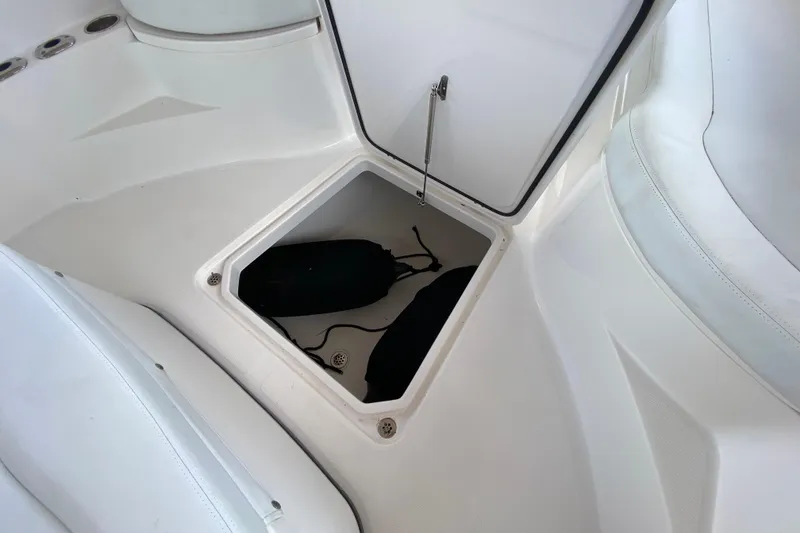 Slide: The Image of 2015 Edgewater 320CC boat storage compartment with open hatch and visible contents. - 27