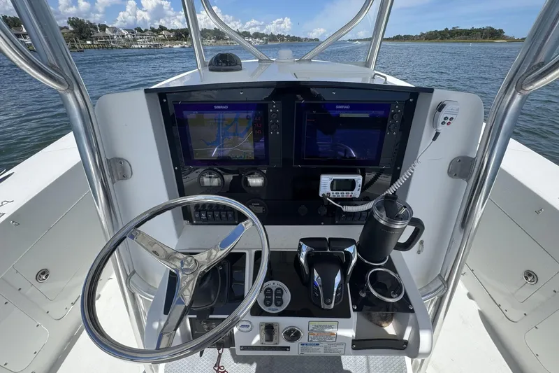 Slide: The Image of 2006 Southport 28 Center Console boat dashboard with navigation screens and steering wheel. - 16