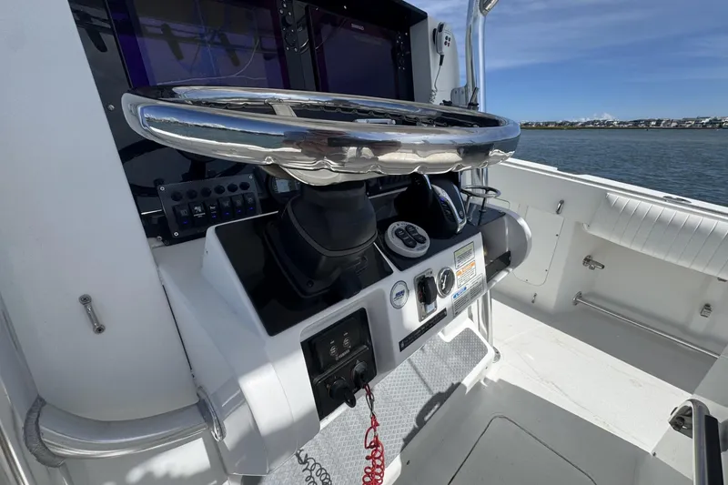 Slide: The Image of 2006 Southport 28 Center Console helm with steering wheel and controls, overlooking water. - 18