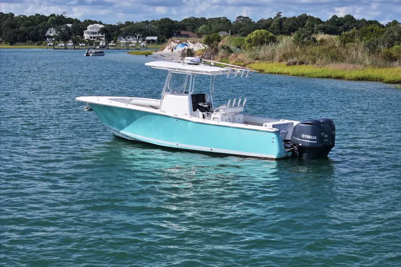 Slide: The Image of 2006 Southport 28 Center Console boat on calm water with scenic background. - 2
