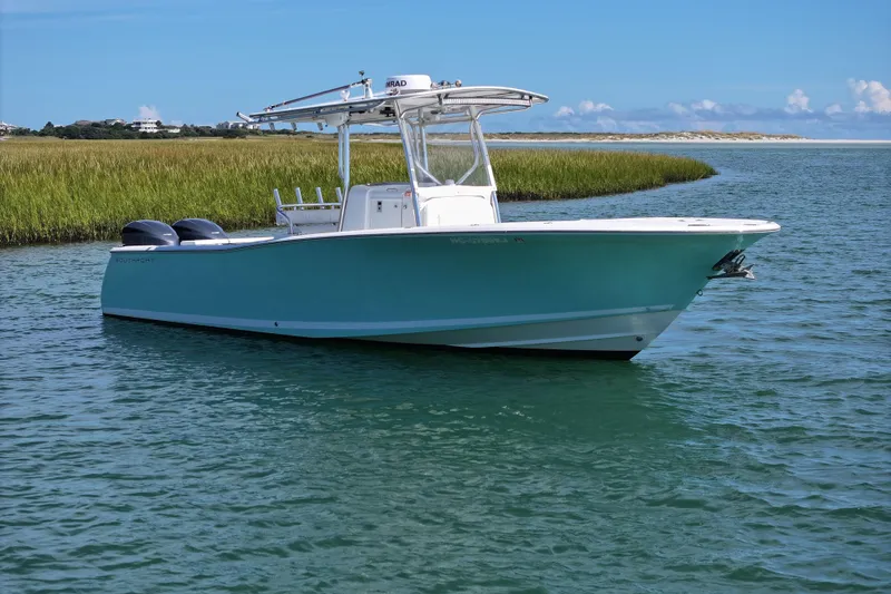 Slide: The Image of 2006 Southport 28 Center Console boat on calm water near grassy shoreline. - 5