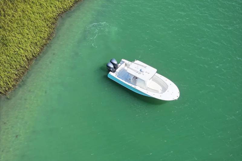 Slide: The Image of Aerial view of a 2006 Southport 28 Center Console boat on turquoise water near grassy shoreline. - 6