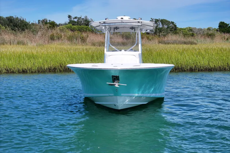 Slide: The Image of 2006 Southport 28 Center Console boat on calm water, lush greenery background. - 8