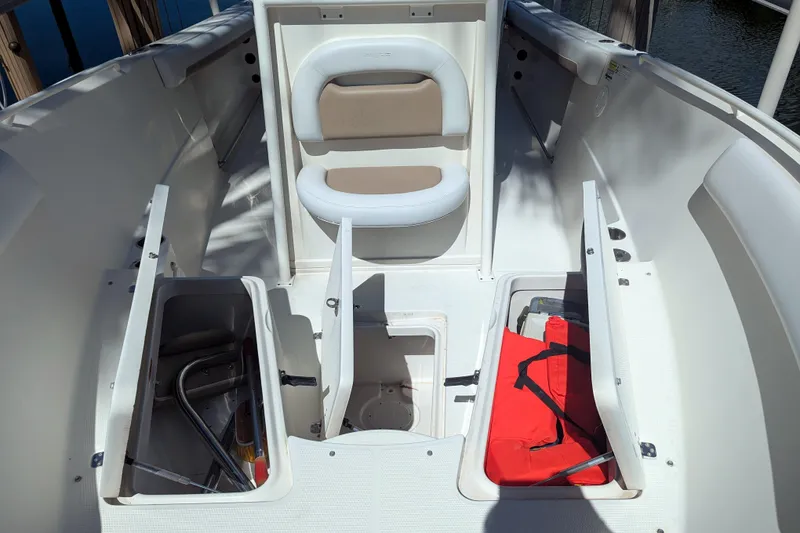 Slide: The Image of 2016 Sailfish 240 CC boat interior with open storage compartments and seating. - 10