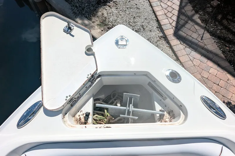 Slide: The Image of Open anchor compartment on 2016 Sailfish 240 CC boat, showing anchor and rope storage. - 12