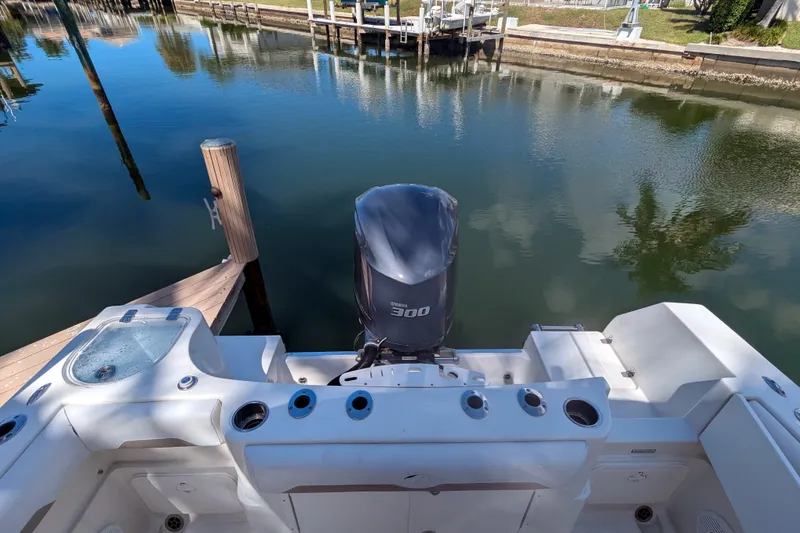 Slide: The Image of 2016 Sailfish 240 CC boat with 300 HP engine docked by calm waters. - 13